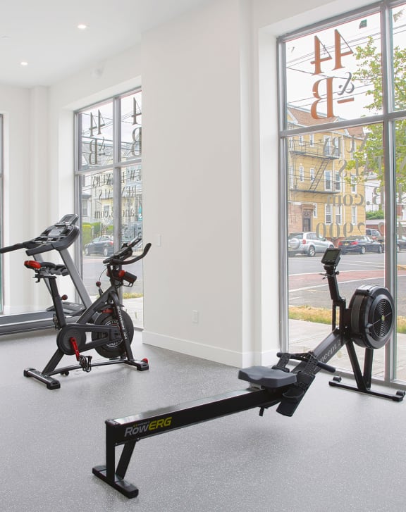 a room with two exercise bikes and a window with a view of the street