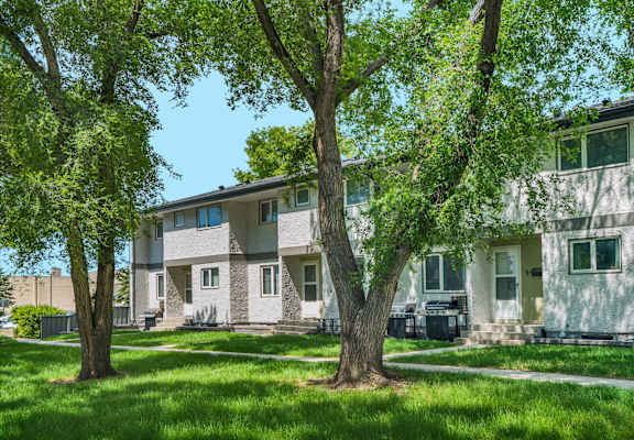 a group of houses with trees in front of them