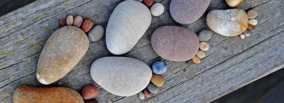 a selection of pebbles on a wooden bench