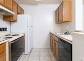 Thumbnail 1 of 10 - A kitchen with a white refrigerator, black oven, and black dishwasher.