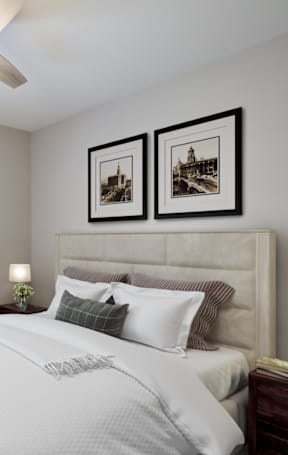 A bedroom with a large bed and two pictures on the wall.