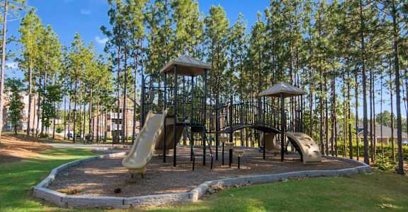A playground with a slide, swings, and a tower.