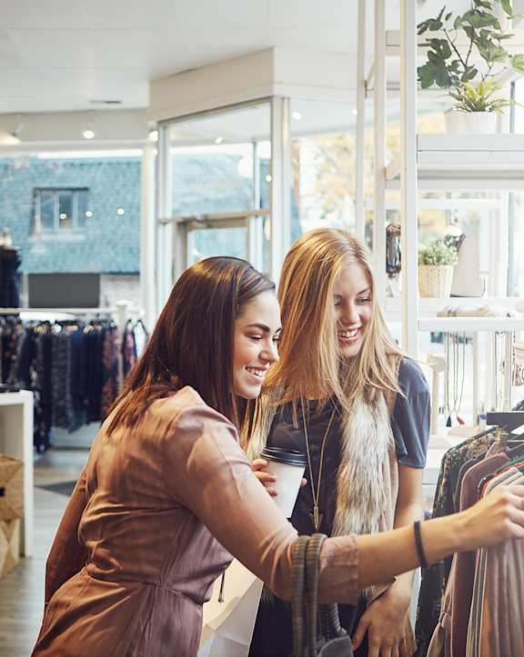 Women Smiling while Clothes Shopping
