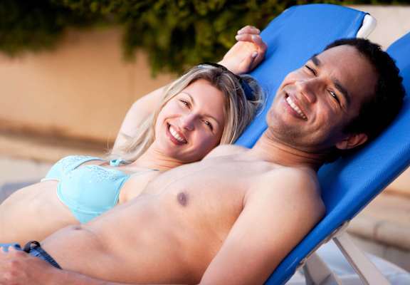 Couple Relaxing By Pool at Windmill Apartments, Colorado Springs, CO