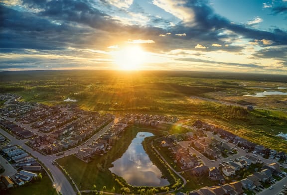 an aerial view of a neighborhood with the sun setting over a residential area
