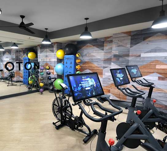 a workout room with a bunch of exercise bikes and balls in it