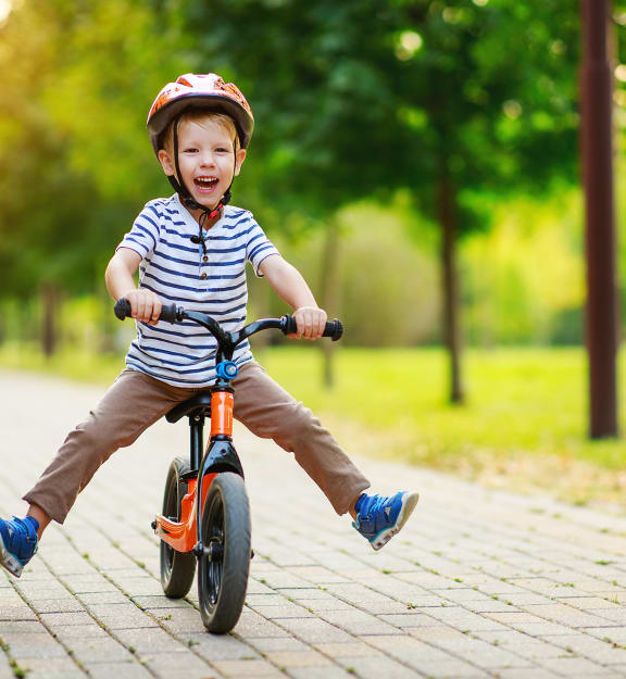 little boy riding a bike in a park