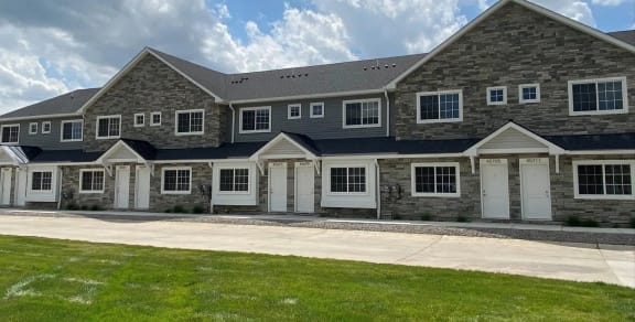 a large brick house with white doors and a blue roof