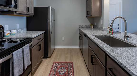 kitchen with granite countertops at the district flats apartments in lenexa, ks