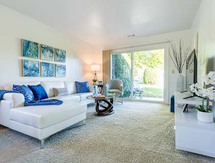 a living room with a white couch and blue pillows