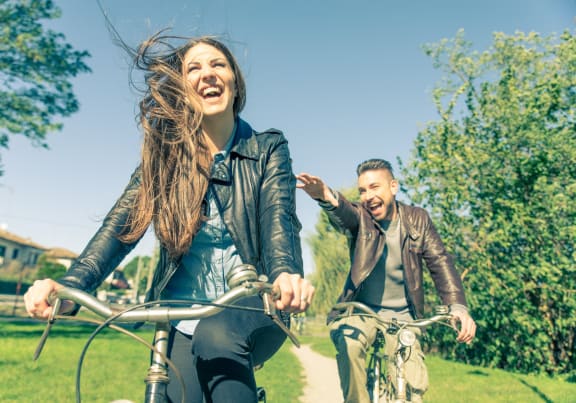 Young Couple Riding Bicycles Together Smiling