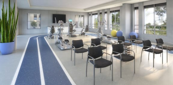 Exercise room with gym equipment, yoga balls, chairs, and natural lighting.