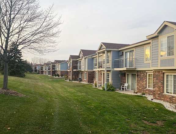 an image of a row of houses on a lawn at Wood Creek Apartments, Wisconsin
