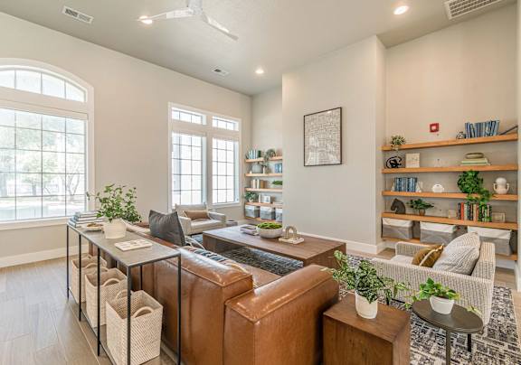 Furnished Living room with brown leather couch at Vivir at Ballpark Village Apartments, Goodyear, Arizona