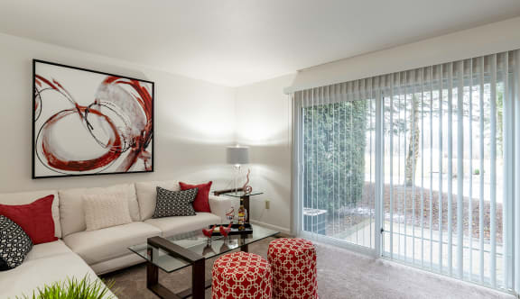 a living room with a white couch and a glass coffee table in front of a sliding glass  at Pheasant Run, Saginaw, 48638