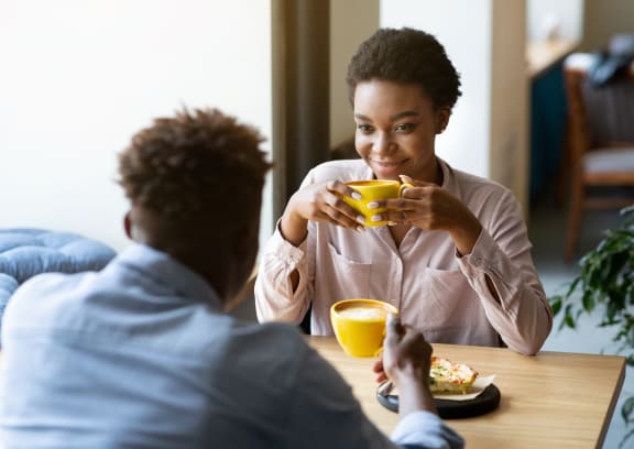 two people sitting at a table drinking coffee