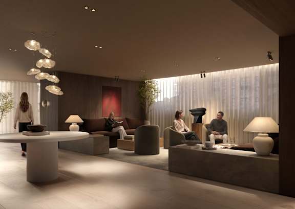 A modern living room with people sitting and standing around.