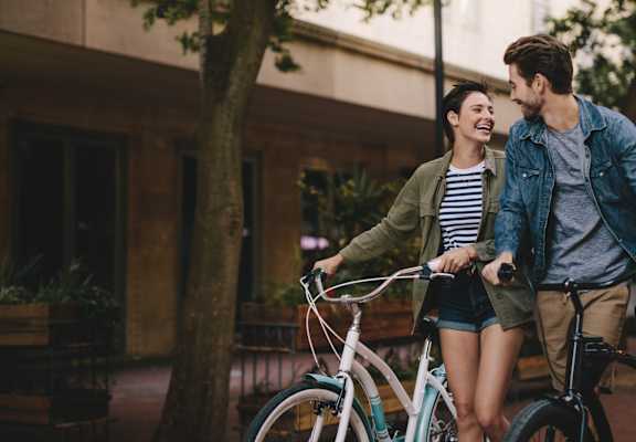 A man and woman are riding bicycles together.