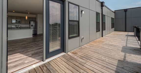 A modern house with a wooden deck and sliding glass doors.