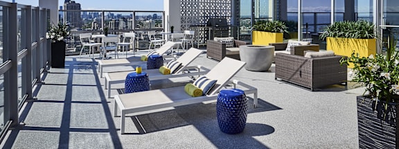 A rooftop patio with white furniture and a white pergola.