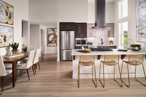 a kitchen with an island and a dining table with chairs