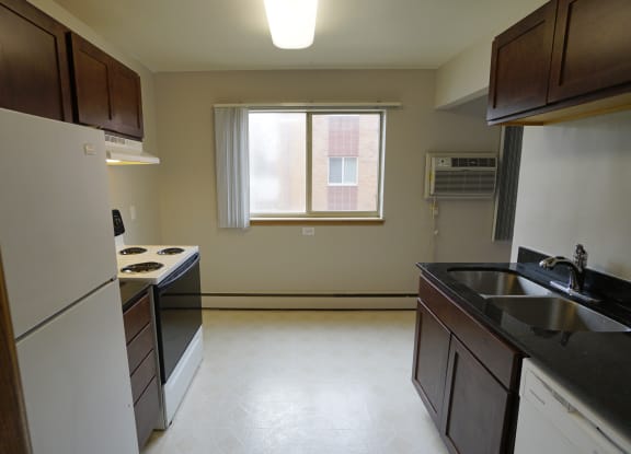 an empty kitchen with a sink stove and refrigerator