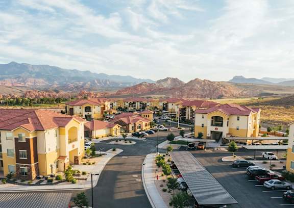 A view of a housing complex with a road and cars.