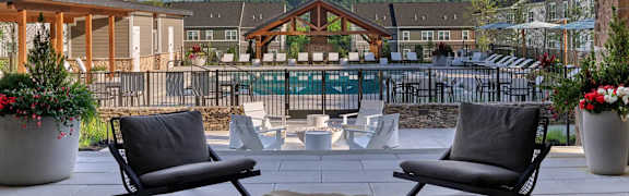 A patio with chairs and a table with a stone top.