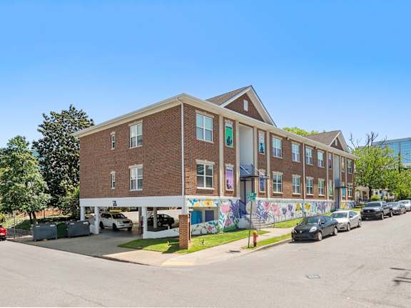 A street view of State Street Flats Apartments with a mural on the side.