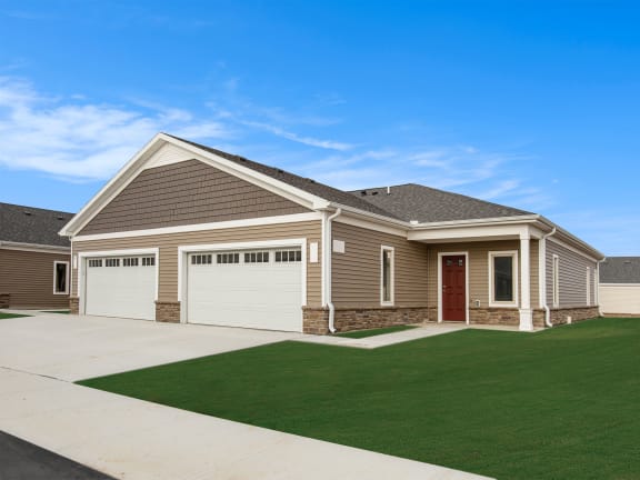 a house with a driveway and lawn in front of it