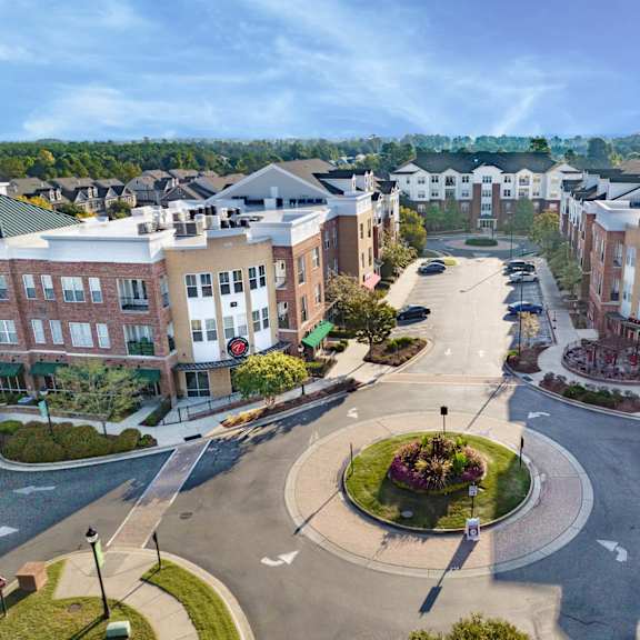 A roundabout in a residential area with buildings on either side.