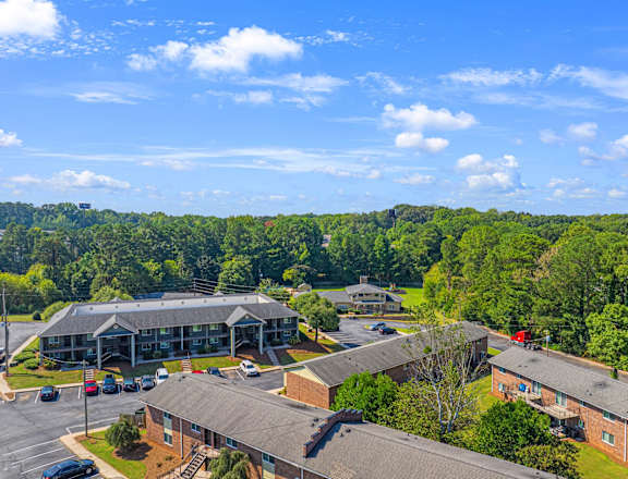 A large building complex with a parking lot in front.