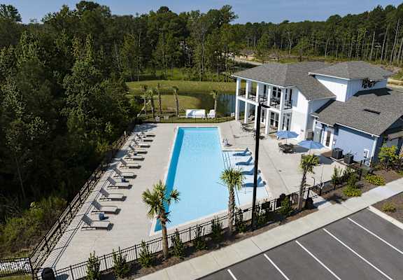 an aerial view of a swimming pool and a building with a resort style pool