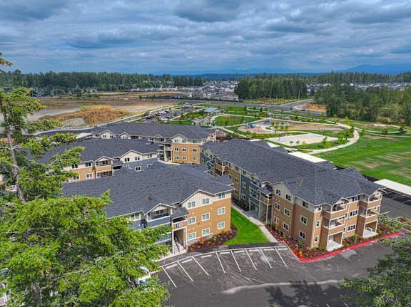 A large apartment complex with a parking lot in front.