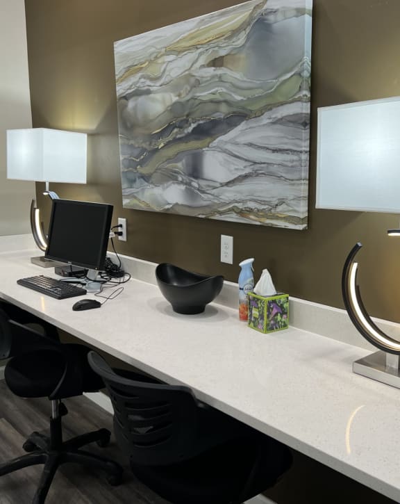 a large desk with a computer and lamps on it