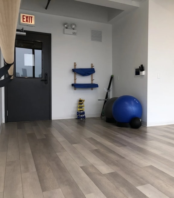 a workout room with a blue ball on the floor and a door