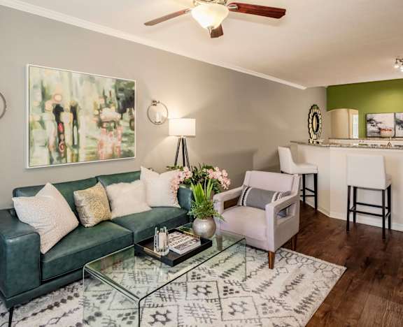 Stylish living room with sofa, accent chair, artwork, and glass coffee table
