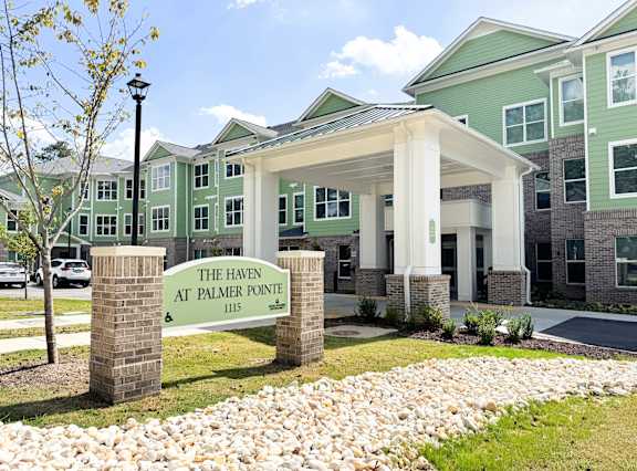 The Haven at Palmer Pointe Senior Apartments Entrance with carport and a sign that reads "The Haven at Palmer Pointe"
