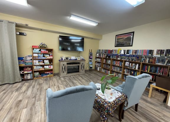 a library with chairs and a table and a tv
