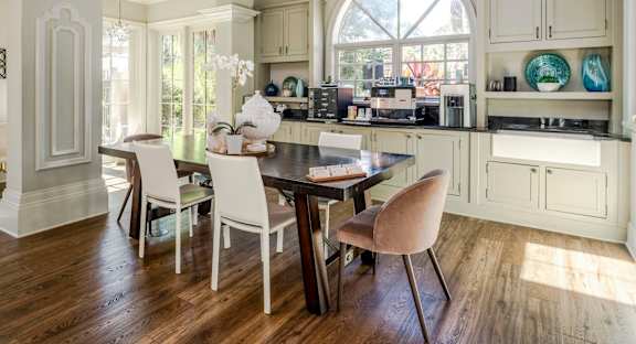Resident coffee bar and dining space featuring custom cabinetry, espresso machine, and warm daylight.