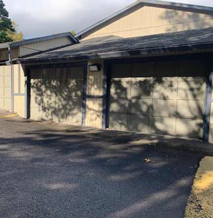 a garage with two garage doors on the side of a building at Ridgecrest Timbers Apartments, Portland, OR 97203