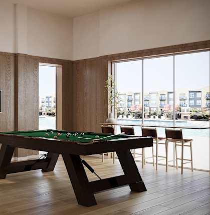 A pool table with a green cloth and a television on the wall.