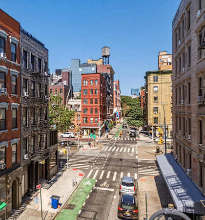 A city street with a car driving down the road.