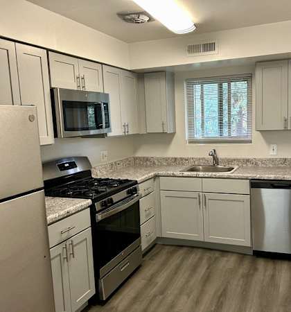 a kitchen with white cabinets and stainless steel appliances