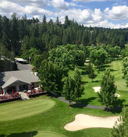 A golf course with a green and a sand trap.