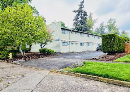 A building with a green hedge in front of it.