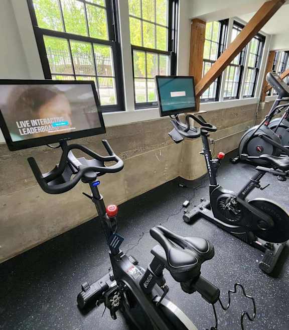 Fitness center with stationary bikes and cardio equipment at The Overlook Apartments, Weymouth
