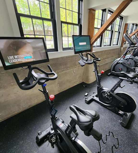 Fitness center with stationary bikes and cardio equipment at The Overlook Apartments, Weymouth, MA