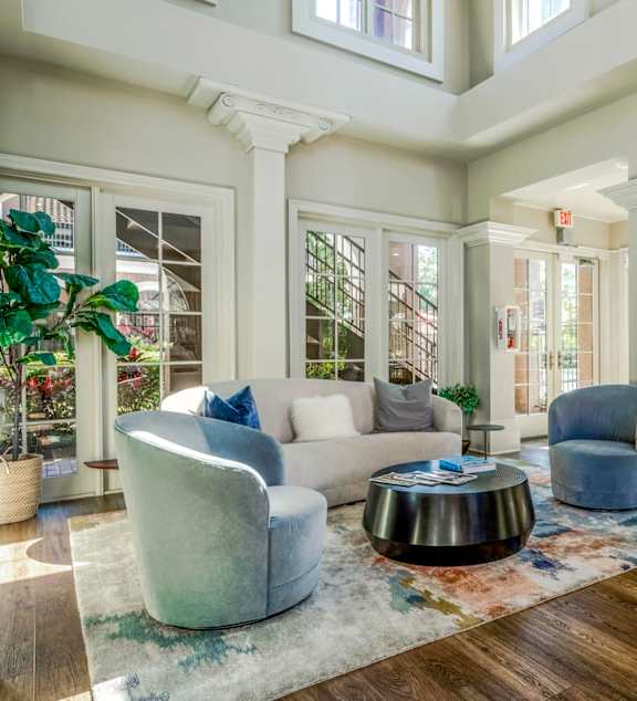 Elegant clubhouse seating area with large windows, plush chairs, and inviting design.
