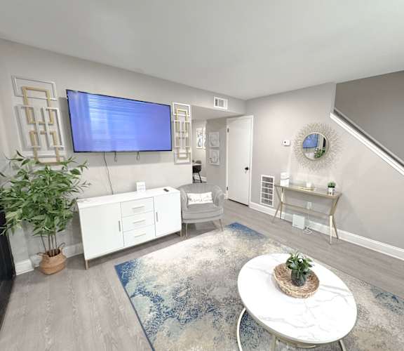 Reserve at Hillcrest model unit staged living room with TV, LVT Flooring, and furniture.